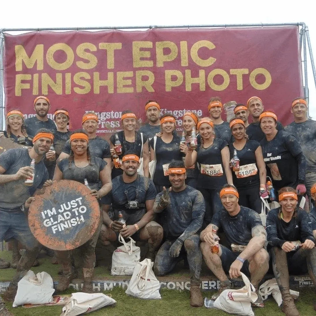 Tough Mudder team finisher photo covered in mud after completing the obstacle course